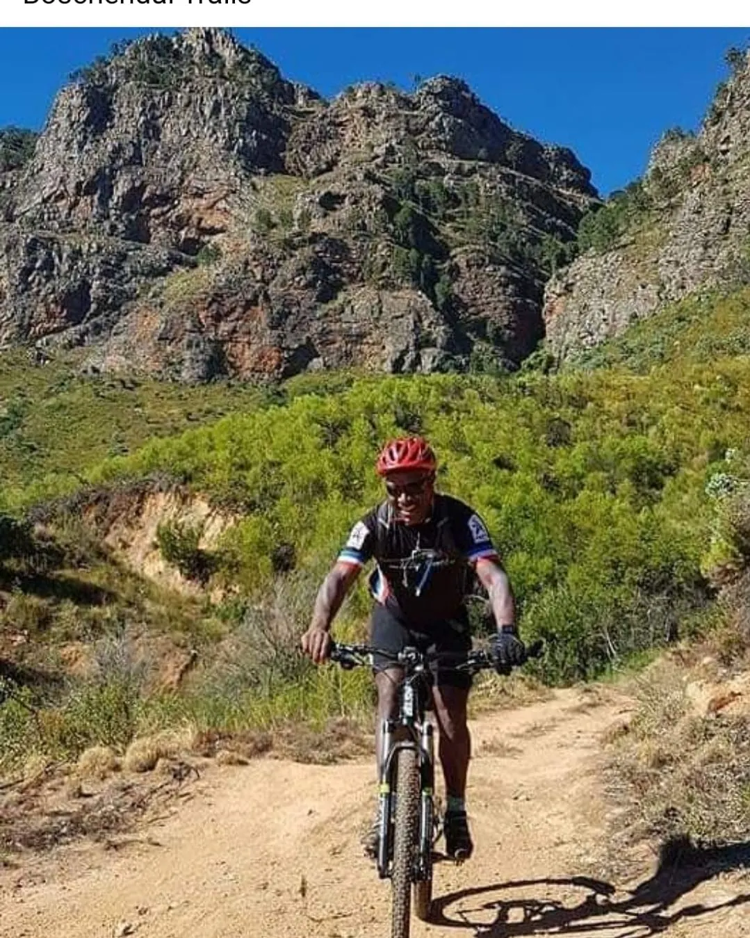 Solly Moeng mountain biking on a scenic trail