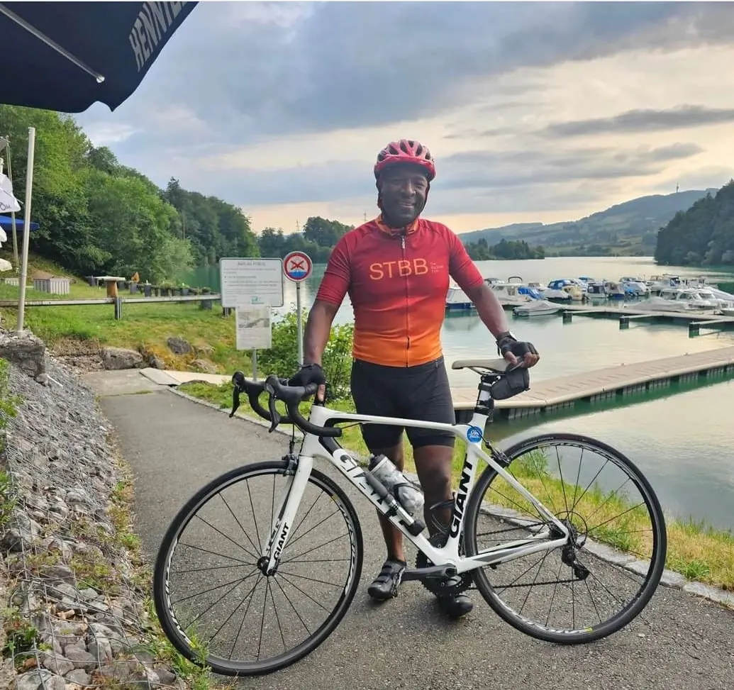 Solly Moeng with a road bicycle beside a lakeside setting