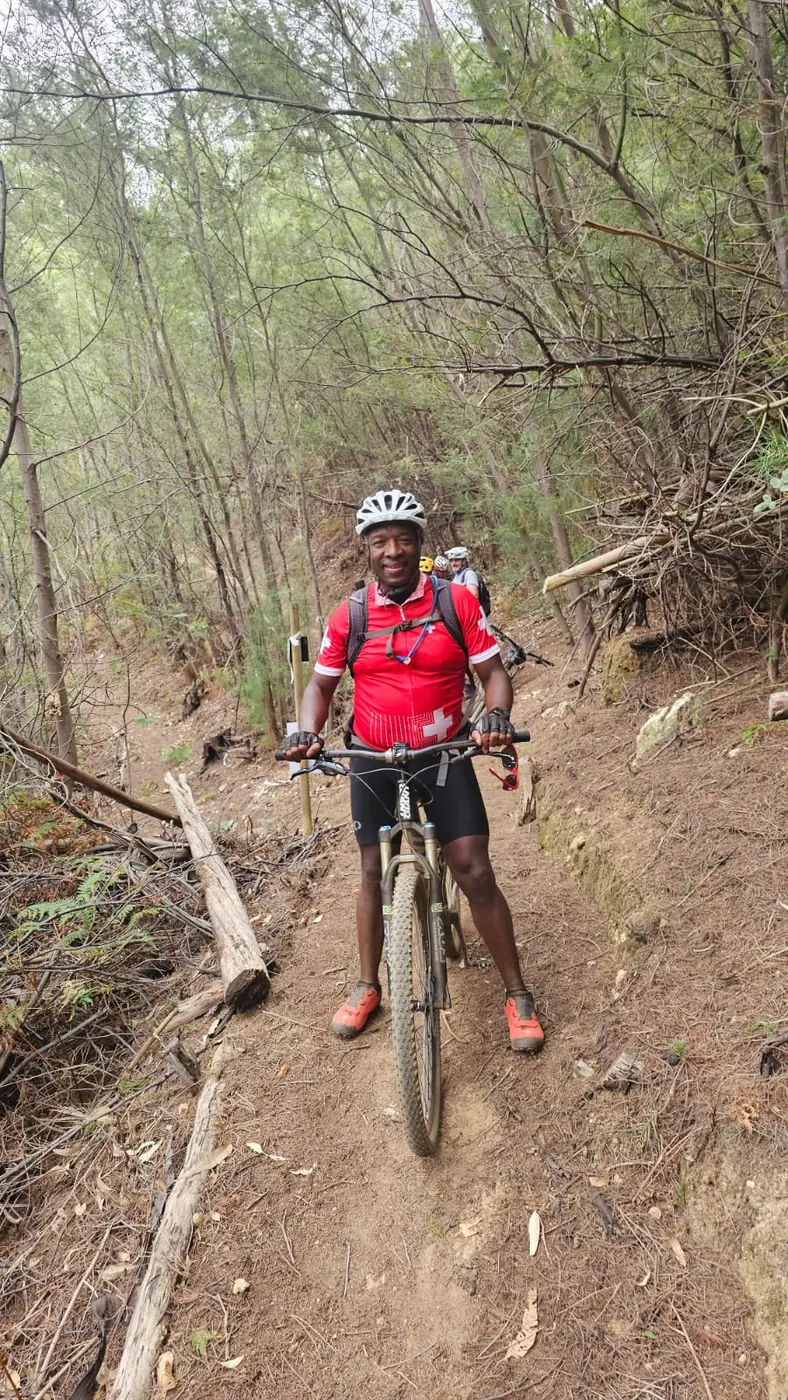 Solly Moeng with a mountain bike on a forest trail