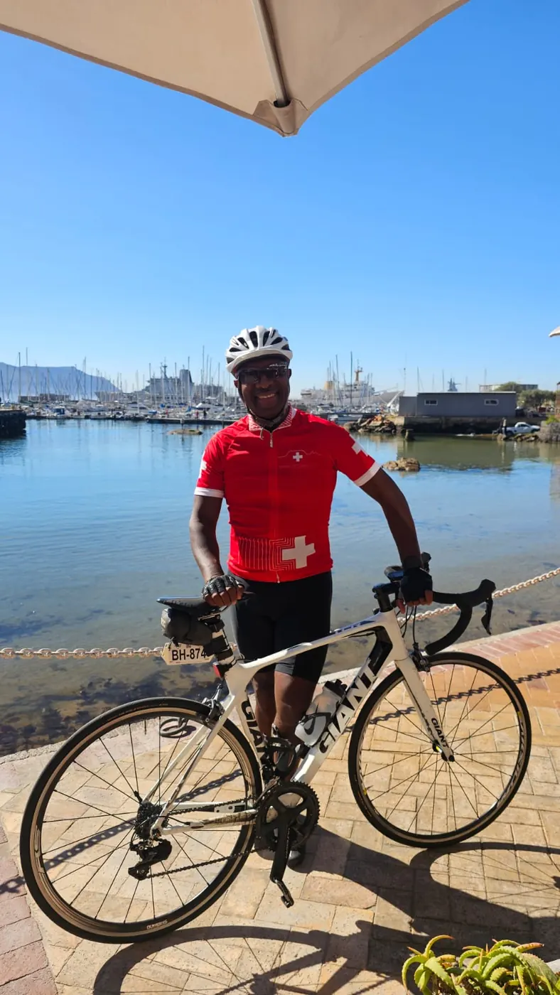 Solly Moeng with a road bicycle near a marina